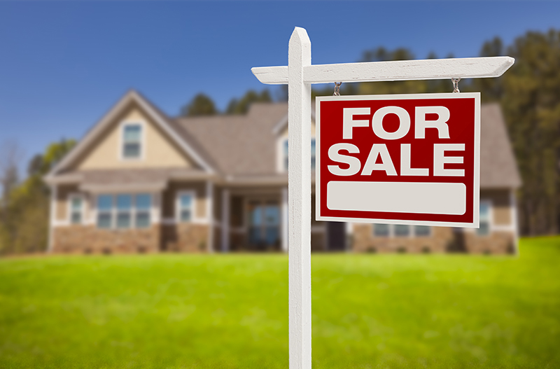 Home For Sale Real Estate Sign in Front of Beautiful New House.