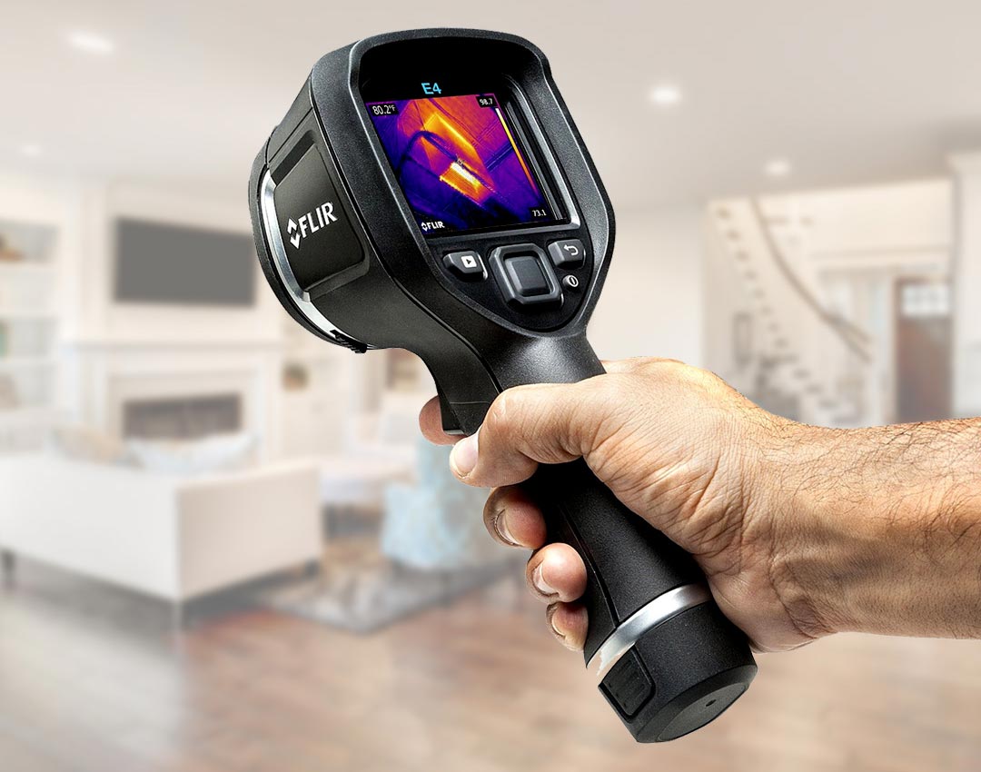 Close-up Of Person Hand Using Infrared Thermal Camera In Living Room At Home